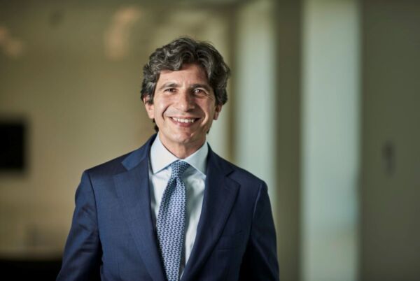 Marco Daviddi, esperto del mercato immobiliare retail in Italia, sorride in giacca e cravatta.