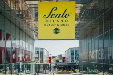 Scalo Milano Outlet & More: vista esterna del centro commerciale con insegna gialla. Shopping a Milano.