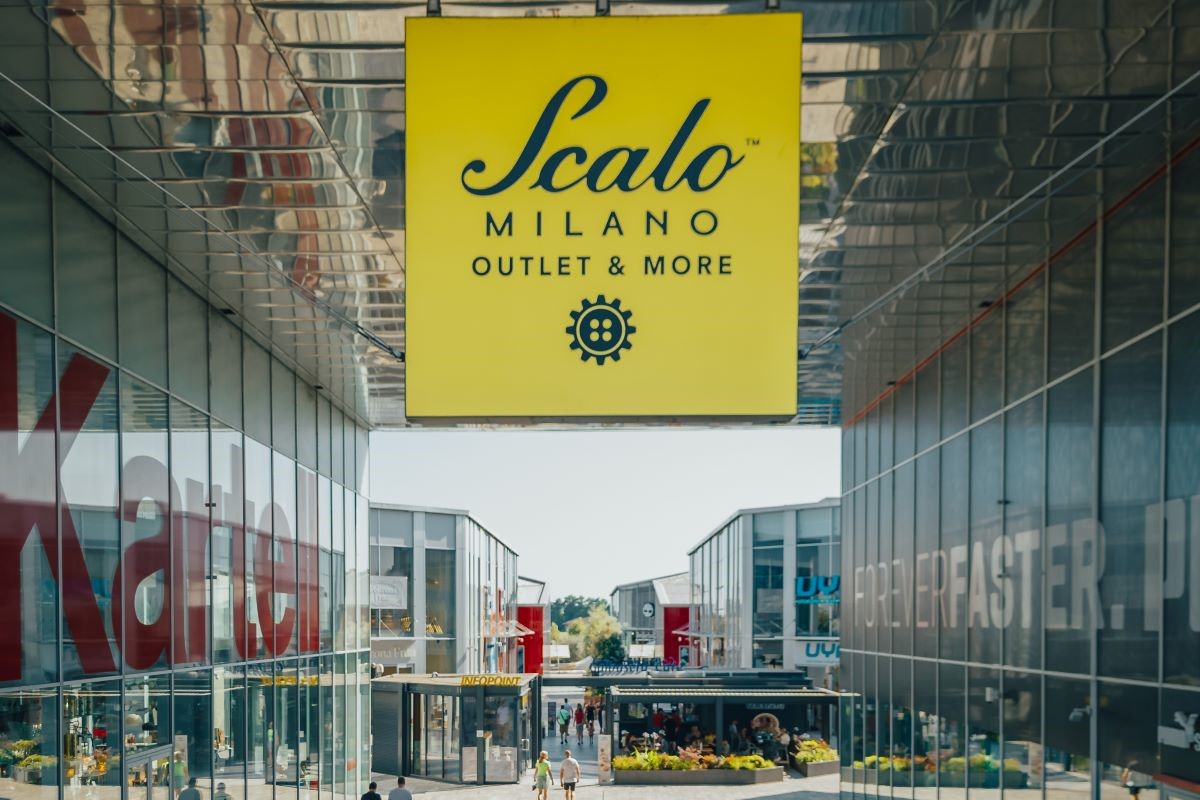 Scalo Milano Outlet & More: vista esterna del centro commerciale con insegna gialla. Shopping a Milano.