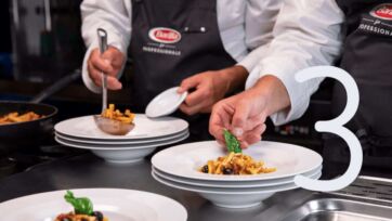 Chef prepara pasta Barilla Al Bronzo per Food Service. Piatti di pasta pronti.