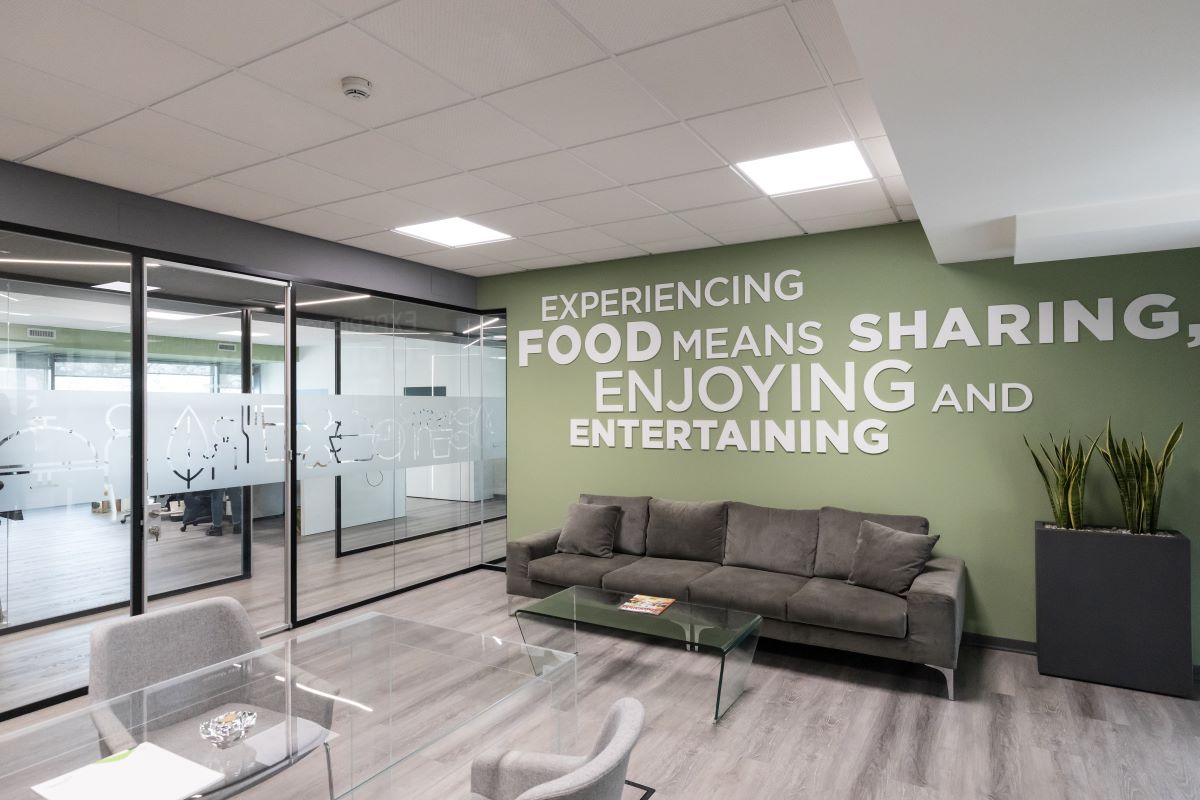 Uffici CIRFOOD Lombardia. Interni moderni, area relax con divano e vetrate decorate. Design ufficio Cologno Monzese.