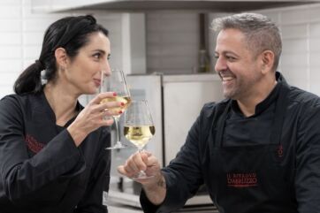 Chef Cristian Di Tillio e sommelier brindano con vino bianco. Ristorante Borgo Baccile.