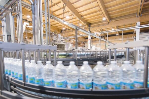 Linea di imbottigliamento Acqua Sant'Anna. Bottiglie su nastro trasportatore nello stabilimento.