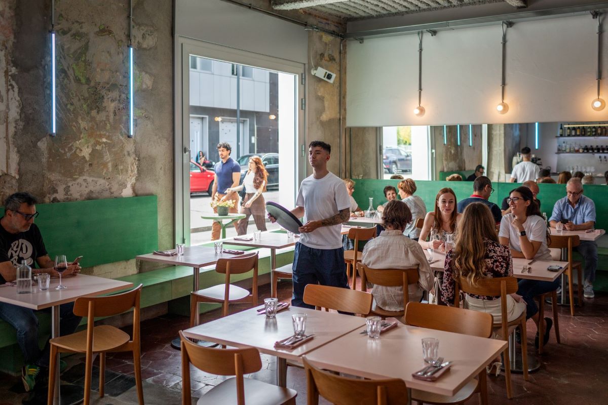 Interno del Club Giovanile Milano, ristorante in zona Certosa. Persone sedute ai tavoli, cameriere.