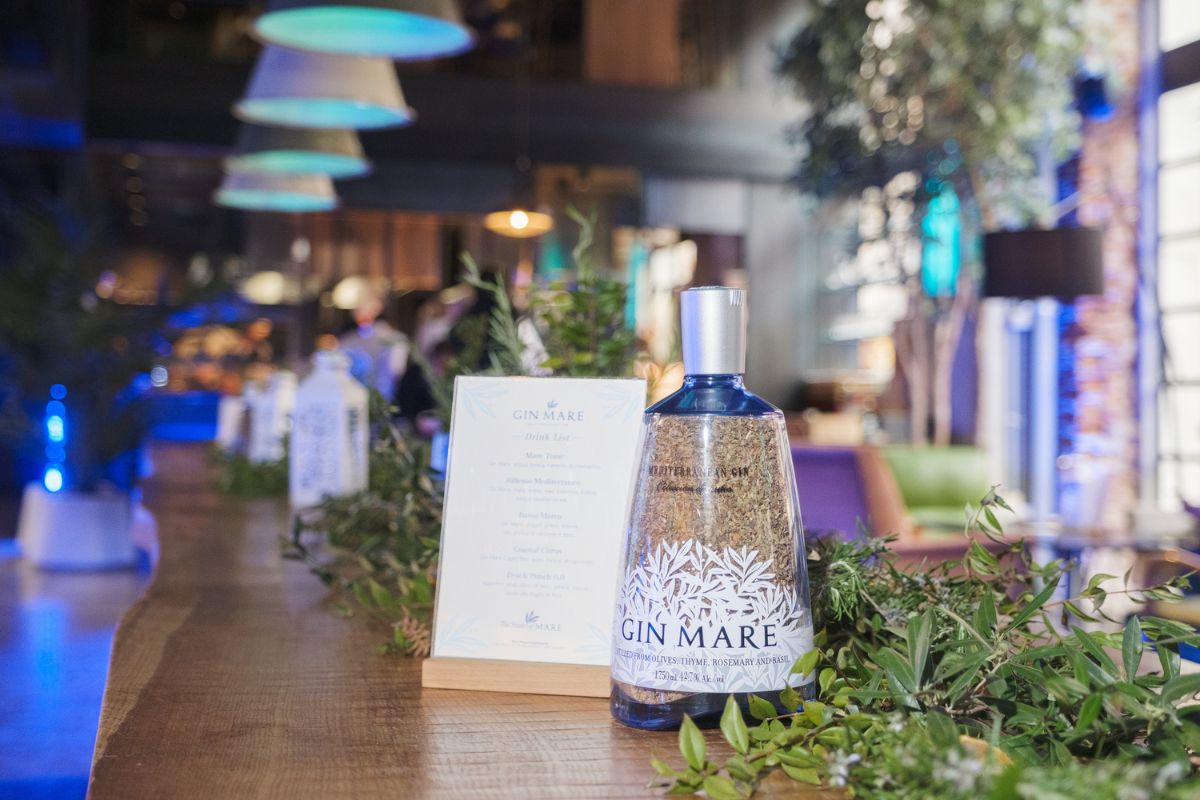 Bottiglia Gin Mare su tavolo in legno. Gin mediterraneo per cocktail e gin tonic.