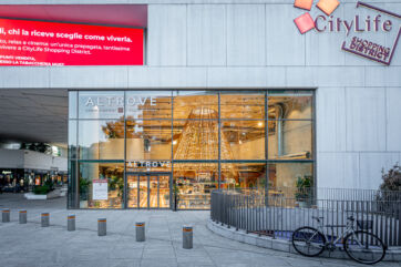 Ingresso Altrove, bistrot Il Viaggiator Goloso a CityLife Milano. Design moderno, vetrine ampie. Bicicletta parcheggiata.