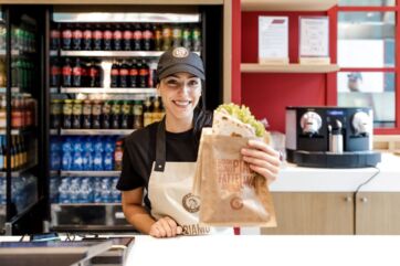 Donna sorridente offre piadina. La Piadineria Chef Express, cibo da viaggio.