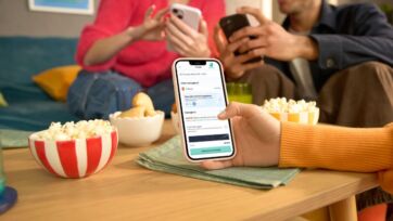 Smartphone con app Deliveroo che mostra Satispay come metodo di pagamento durante una serata con amici e popcorn.