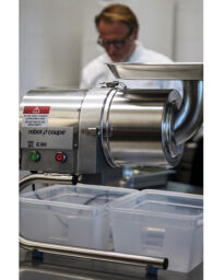 Passatrice professionale Robot Coupe C80 in acciaio inox utilizzata in cucina professionale con contenitori in plastica.