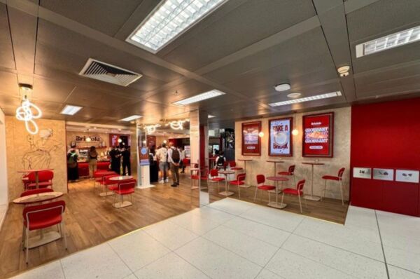 Nuovo design del locale Briciole negli aeroporti di Milano Linate e Malpensa con tavoli, sedie rosse e insegne luminose.