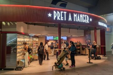 Punto vendita Pret A Manger presso la stazione Alta Velocità di Bologna con clienti che scelgono cibo fresco.