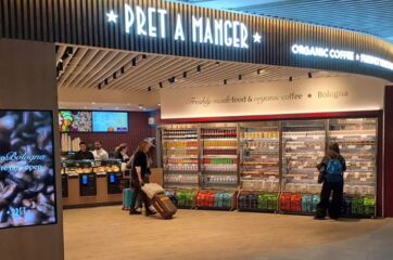 Nuovo punto vendita Pret A Manger presso la stazione di Bologna Centrale, con scaffali di cibo fresco e caffè bio.