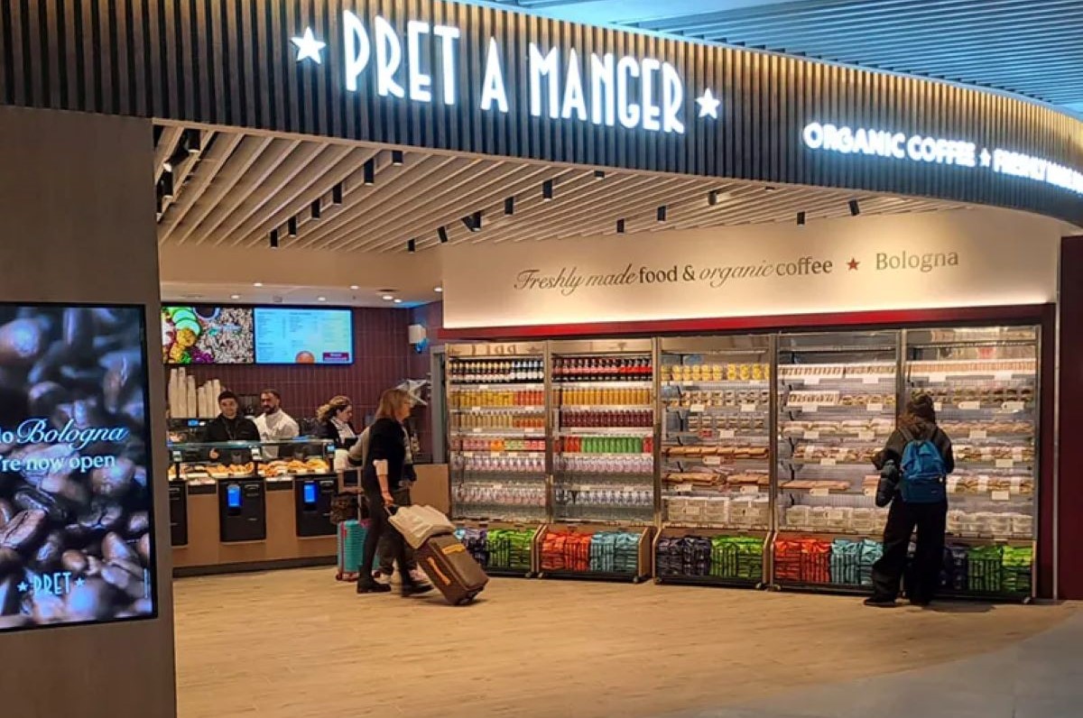 Nuovo punto vendita Pret A Manger presso la stazione di Bologna Centrale, con scaffali di cibo fresco e caffè bio.