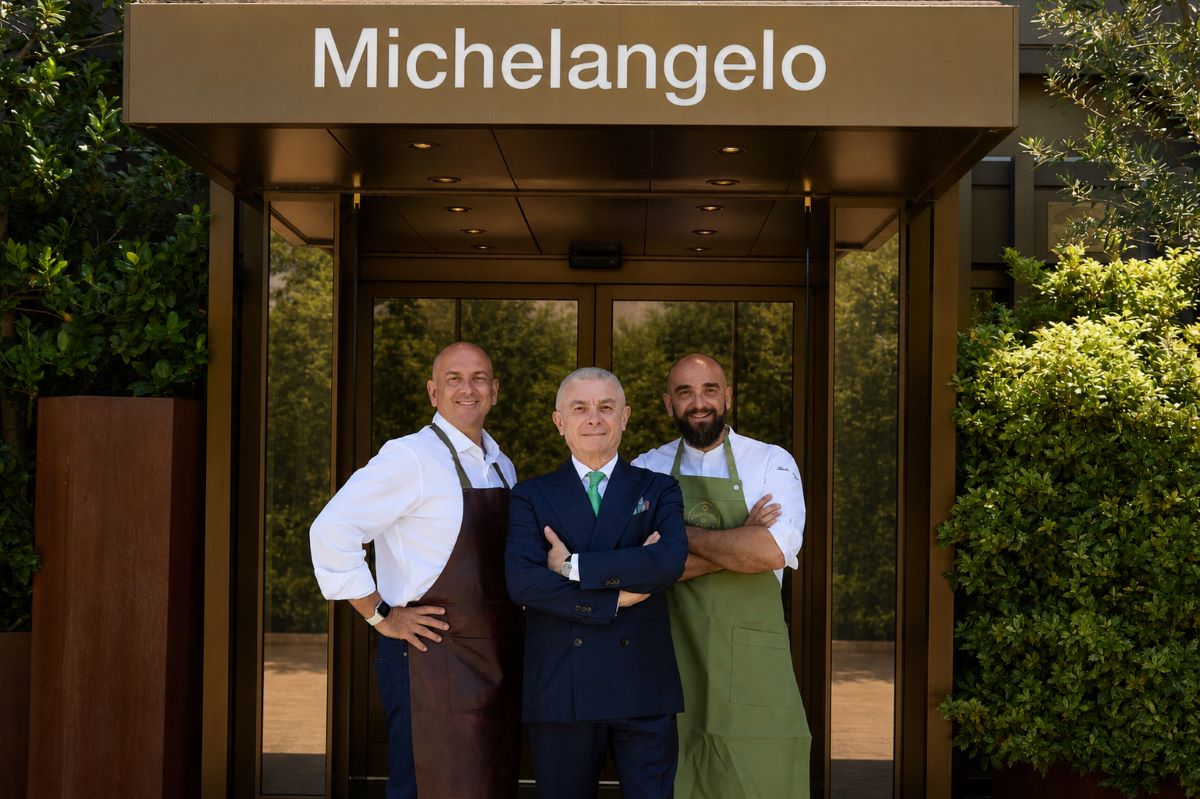 Staff dello Starhotels Michelangelo Firenze insieme agli chef della Trattoria Da Burde davanti all'ingresso dell'hotel.