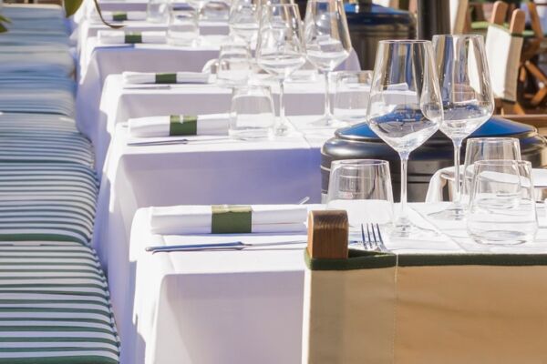 Tavoli apparecchiati con eleganza presso il ristorante Casamare, con bicchieri di vino e tovaglioli verdi in primo piano.