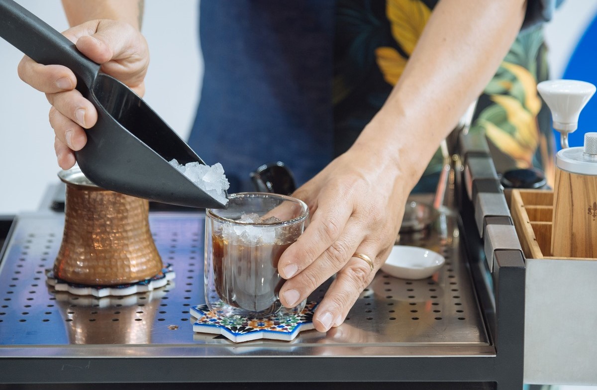 Preparazione caffè ghiacciato con caffettiera per la Giornata Internazionale del Caffè e consumo consapevole