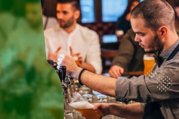 Barman versa una birra alla spina in un locale, rappresentando l'eccellenza del servizio per Heineken Italia.