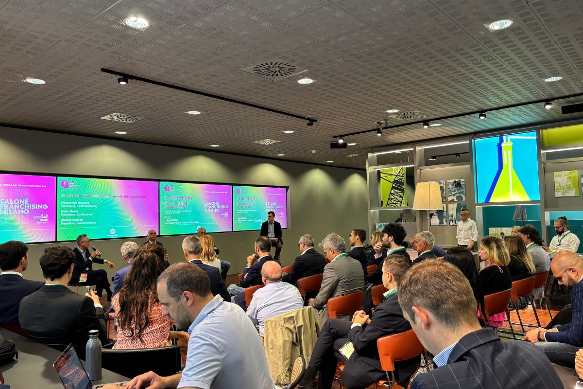 Conferenza al Salone Franchising Milano con relatori sul palco e pubblico attento in sala per l'evento di business.