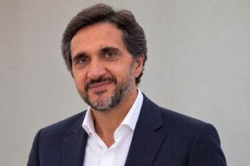 Ritratto del CEO di Sonae Sierra con capelli scuri e barba, indossa giacca blu e camicia bianca su sfondo neutro