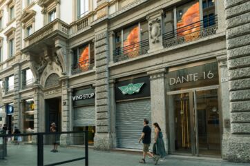 Facciata del nuovo ristorante Wingstop a Milano in via Dante 16, con insegna e vetrine in un elegante palazzo storico.