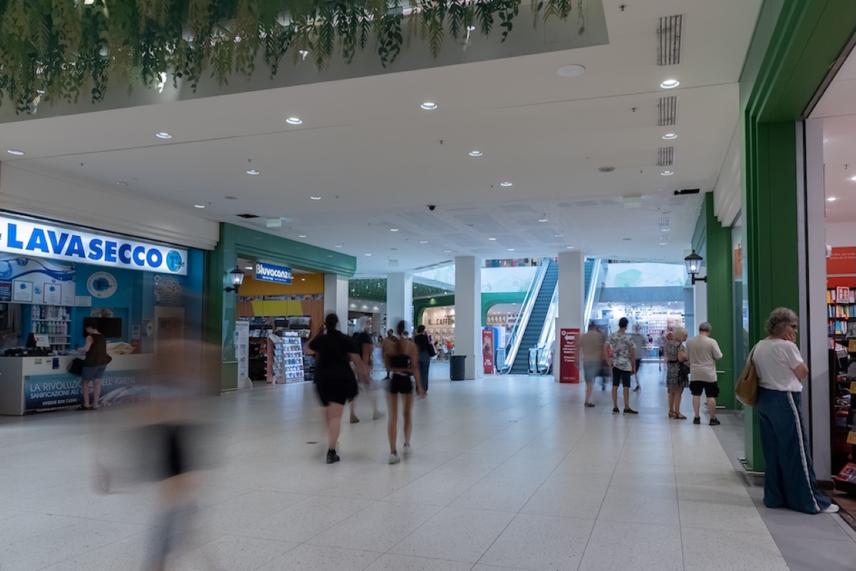 Centro commerciale Rescaldina: interno rinnovato del primo piano con persone, negozi e scala mobile