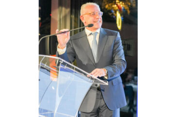 Roberto Zoia, Presidente CNCC e AD di IGD, parla al microfono dietro il leggio durante un evento.
