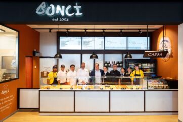 Bonci Roma Termini: bancone con pizza al taglio e staff del locale alla stazione.