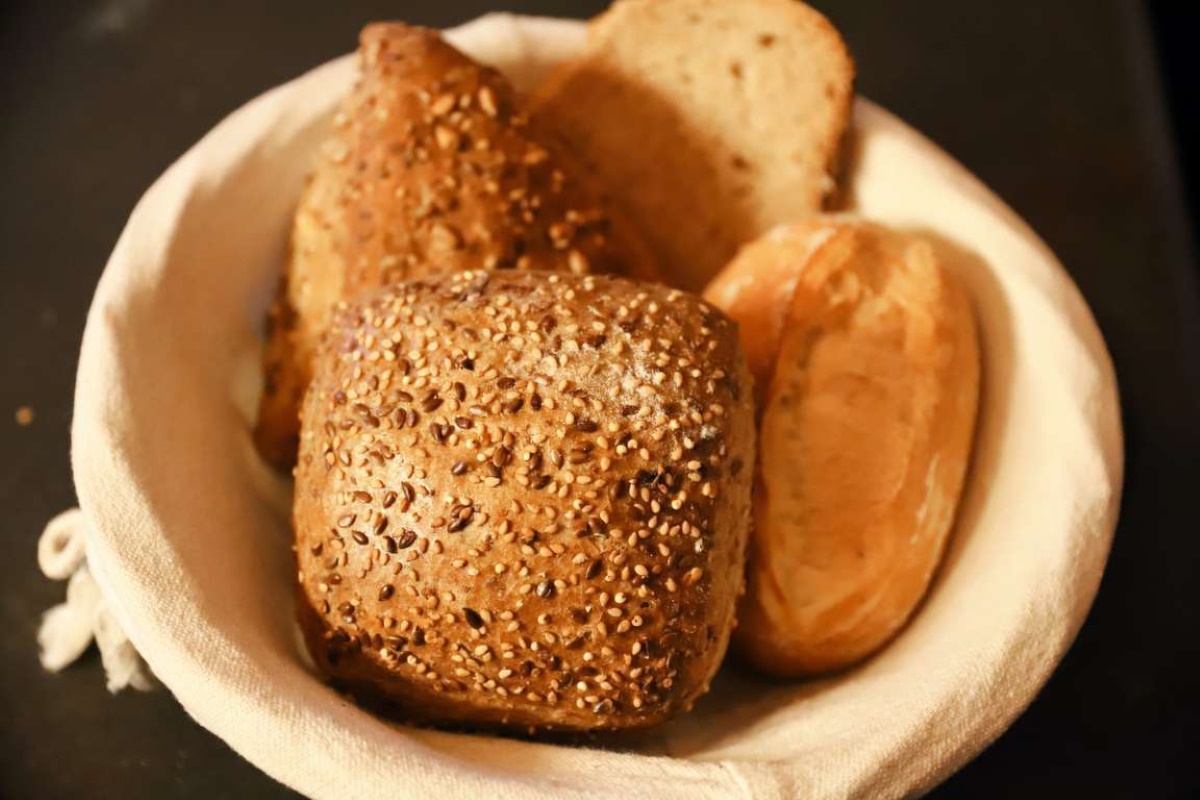 Cestino di pane con panini integrali ai semi, pagnotta e pane della tradizione per la Giornata mondiale del pane