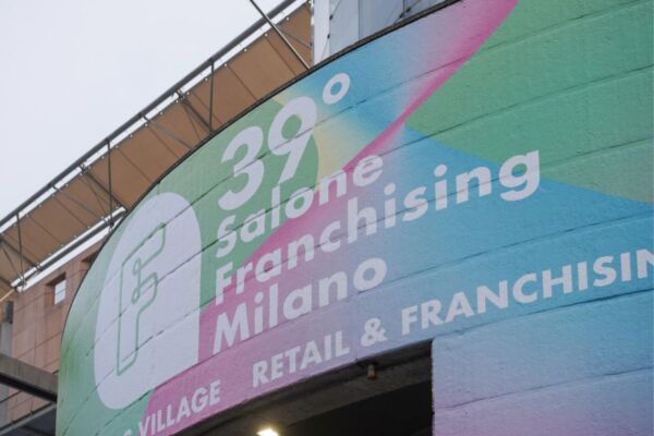 Insegna del 39° Salone Franchising Milano con grafica colorata e logo, evento dedicato a retail e franchising.