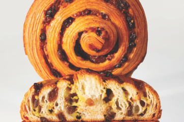 Pain aux raisins alla nocciola. Brioche sfogliata con uvetta e crema. Pasticceria francese.