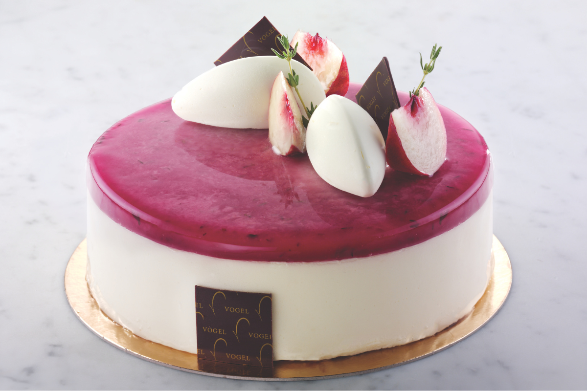Cheesecake Tokyo elegante. Glassa ai frutti di bosco, decorata con pesche, cioccolato e crema.
