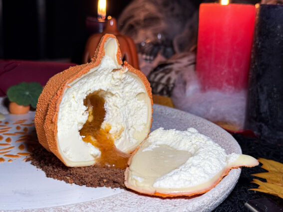 Dolce Halloween: zucca di pasticceria ripiena di crema. Dessert spaventoso e goloso per una festa da brividi.