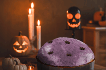 Panettone viola di Halloween. Dolci spaventosi, zucche, candele e decorazioni a tema Halloween.