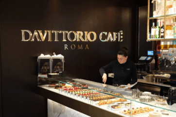 Da Vittorio Café Roma: pasticceria artigianale e caffetteria. Donna al lavoro dietro il bancone.