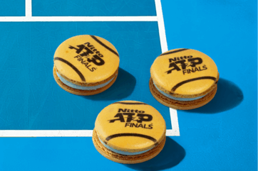 Macarons Iginio Massari ATP Finals Torino. Dolci a forma di pallina da tennis su campo blu.