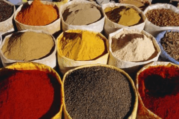 Spezie colorate in sacchi. Tendenze globali dei sapori 2025. Curry, paprika, curcuma, pepe nero, spezie miste.