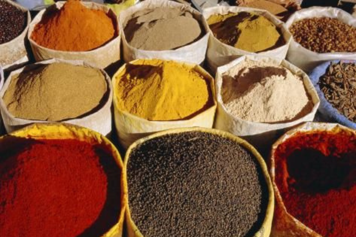 Spezie colorate in sacchi. Tendenze globali dei sapori 2025. Curry, paprika, curcuma, pepe nero, spezie miste.