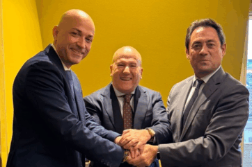 Accordo Puratos Italia e Cascarano. Tre uomini in giacca si stringono la mano. Partnership nel settore alimentare in Puglia.