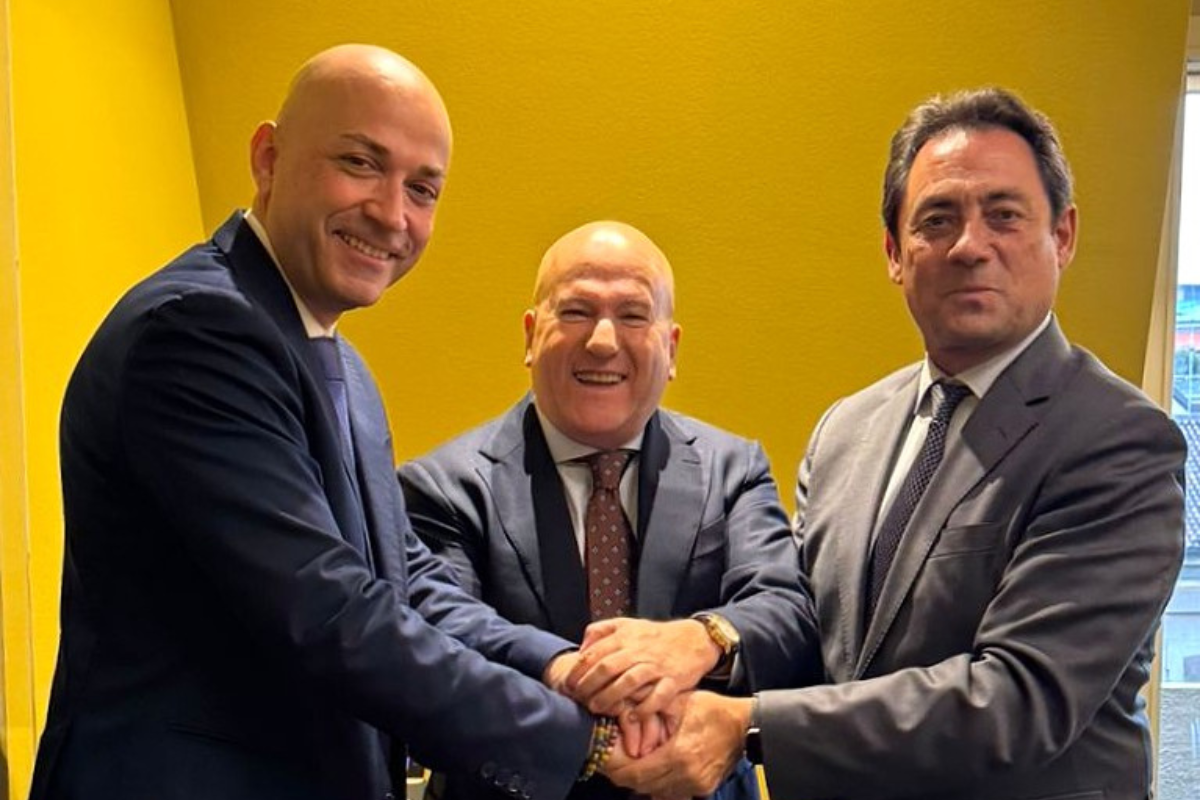Accordo Puratos Italia e Cascarano. Tre uomini in giacca si stringono la mano. Partnership nel settore alimentare in Puglia.