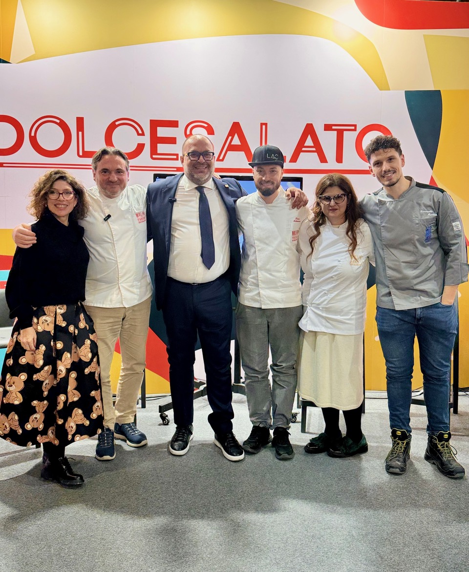 Gruppo di persone a Dolcesalato, evento filiera OIRZ Molini Fagioli. Chef e relatori sorridono.