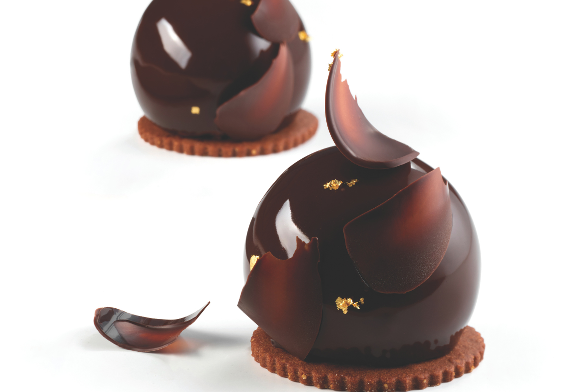 Dolci Lunanera: sfera di cioccolato lucido con decorazioni e base di biscotto. Pasticceria artigianale.