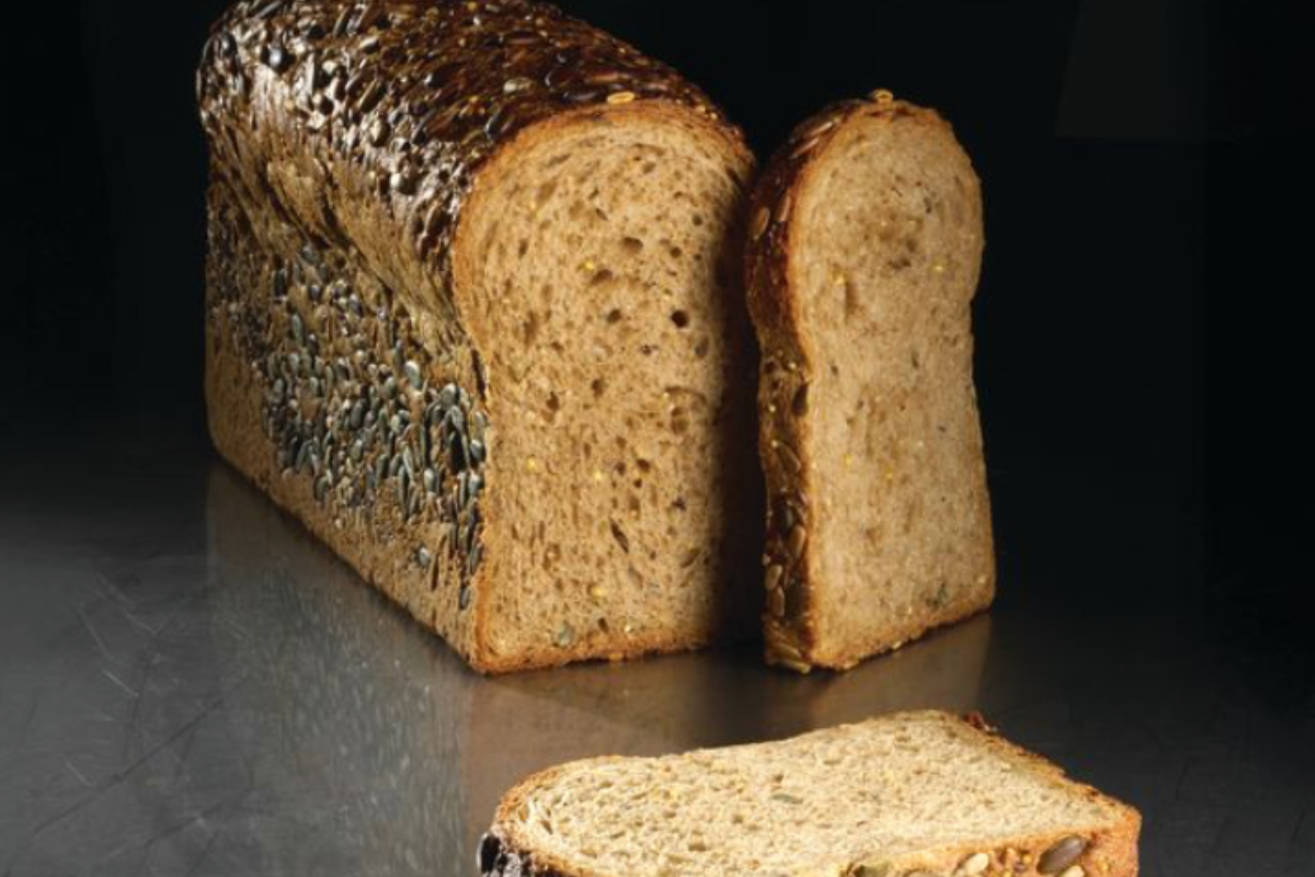 Cassetta di pane integrale ai semi, fette tagliate. Pane fatto in casa, nutriente e gustoso.