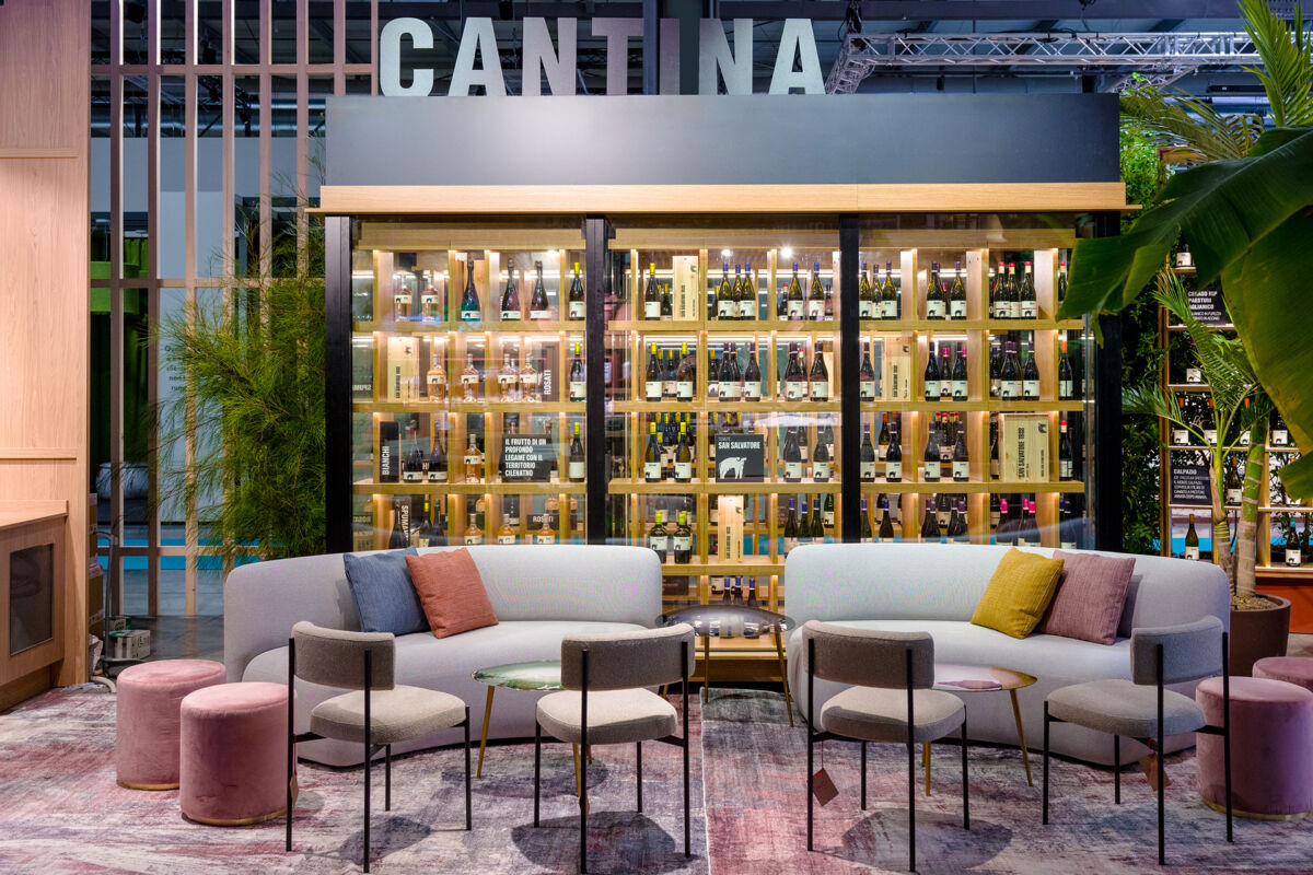 Tecnoarredamenti Euroshop: design cantina vini con divani, sedie e scaffali illuminati. Arredamento su misura.