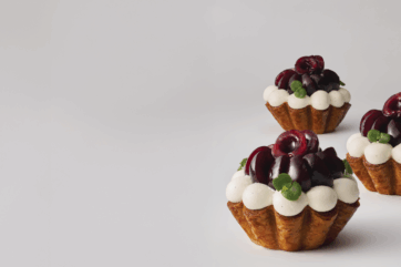 Tartellette clafoutis alle ciliegie. Dolci con crema, ciliegie fresche e pasta sfoglia.