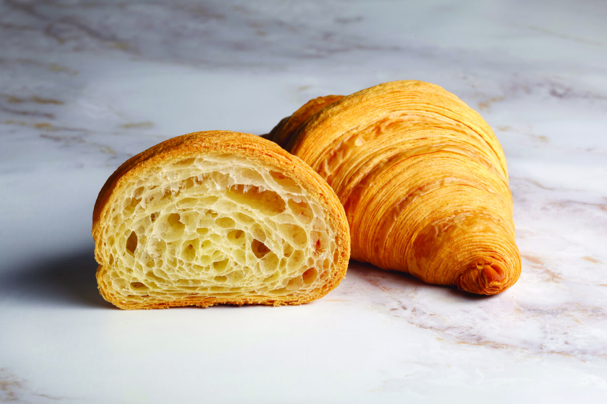 Croissant sfogliato: pasta lievitata, doratura perfetta e alveolatura interna.