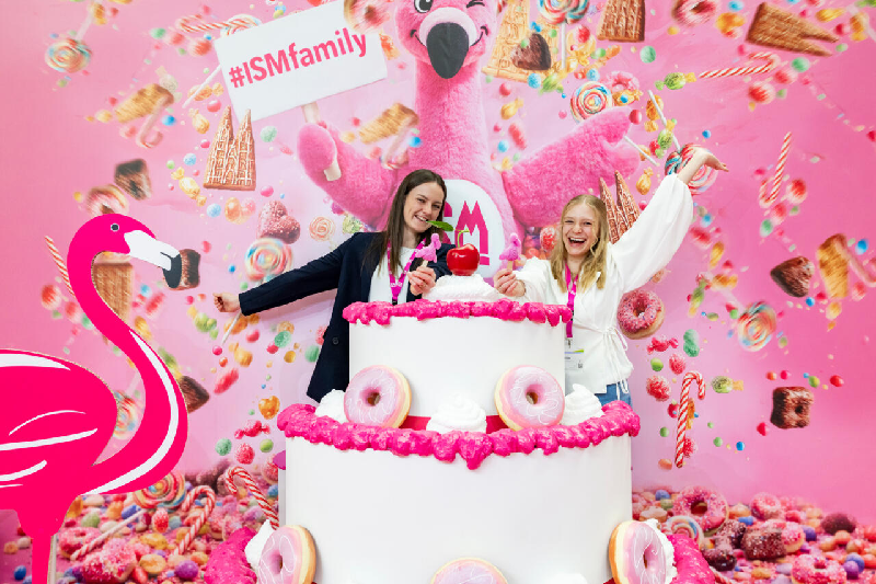 ISM 2026: Stand colorato con torta, fenicotteri e caramelle. Networking e dialogo internazionale.