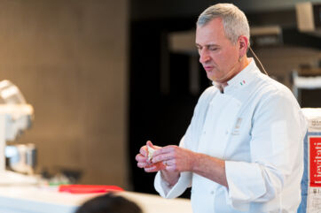 Chef italiano in divisa bianca lavora pasta. Esperto di panificazione e lievitati. Cucina italiana di alta qualità.