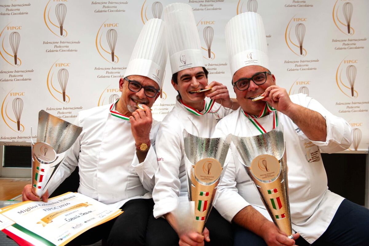 Podio Miglior Colomba Italia 2026. Pasticceri con trofei e medaglie. Eccellenza artigianale italiana.