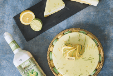 Dolce agli agrumi: torta al limone e lime, fetta di torta, bottiglia di limoncello. Dessert fresco e goloso.