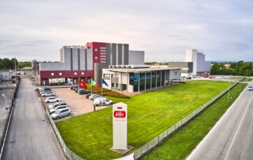 Stabilimento Lago dal 1968. Industria dolciaria italiana, sede aziendale con parcheggio e bandiere.